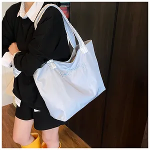 Detailed texture of light blue canvas tote bag with I'm Creamy embroidery for women