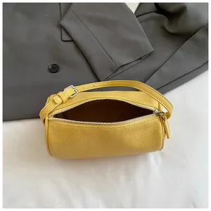 Dettaglio della borsa a bauletto gialla in pelle con cerniera e tracolla regolabile