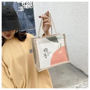 Detail of mini canvas tote bag featuring orange print and braided cotton rope handles