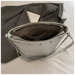 Silver quilted bucket bag with chain strap and studded metallic finish for women
