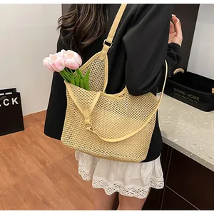 Detail view of large hollow beige woven tote bag with shoulder strap and floral decor