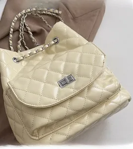 Detail of quilted leather texture and silver chain strap on cream white backpack