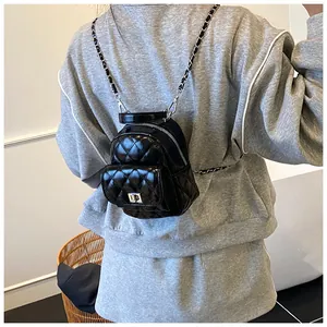 Vista detallada de la mini mochila acolchada con correas de cadena y cierre giratorio