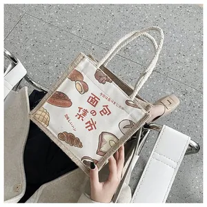 Detailed macro view of a linen and jute tote bag featuring realistic bread illustrations