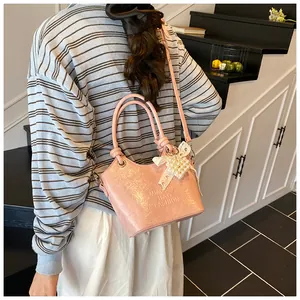 Details der rosa Vintage Eimertasche mit Perlenbogen und geprägtem Schriftzug