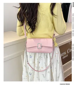 Rear view of model wearing pink pebbled leather shoulder bag with silver lock and chain