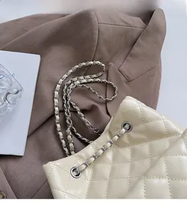 Close-up of beige quilted leather chain bag featuring an elegant drawstring closure