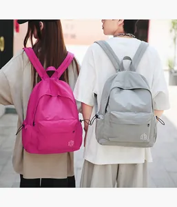 Vue détaillée de sacs à dos minimalistes rose et gris avec texture quadrillée et poches