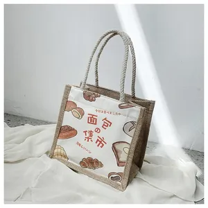 Detail of linen tote bag featuring hand-drawn bread illustrations and jute textures
