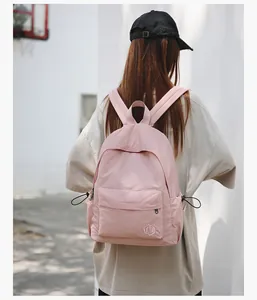 Vue de dos d'un sac à dos décontracté rose avec logo brodé et poches latérales à cordon