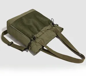 Détail d'un grand sac cabas en nylon vert olive avec poches filet et cordons de serrage