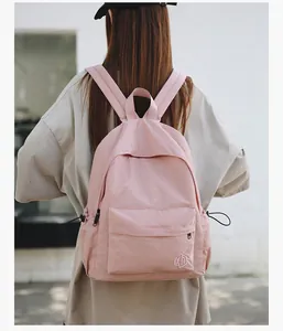 Détail du sac à dos décontracté rose clair avec broderie XD et poches à cordon