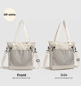 Gros plan d'un cabas beige avec poche en maille grise et bandoulière réglable