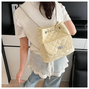 Close-up of quilted beige chain backpack with silver twist-lock and drawstring detail