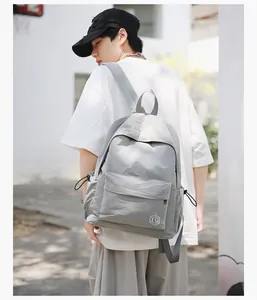 Vue extérieure d'un sac à dos à carreaux gris montrant le profil et les poches latérales