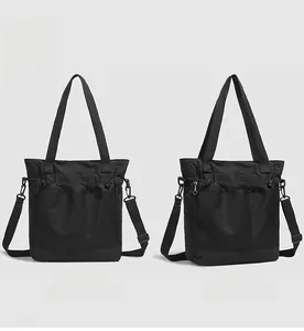 Vue détaillée du sac fourre-tout en nylon noir avec poche en filet et profil latéral