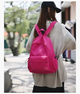 Photo en extérieur d'un sac à dos en nylon rouge rose vif avec grande capacité pour femme