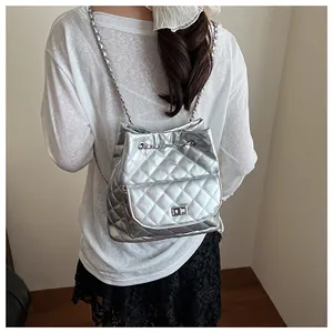 Fashionable silver quilted leather backpack with chain straps shown on a model's back