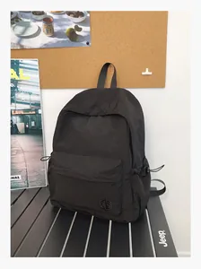 Vue détaillée du sac à dos noir léger avec poches latérales à cordon et logo discret