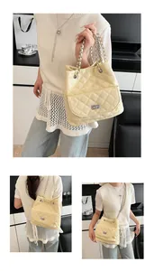 Detail of quilted creamy yellow bag with silver chain strap and metal rotary lock