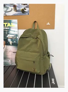 Détail du sac à dos en nylon vert olive avec texture ripstop et logo sur un bureau