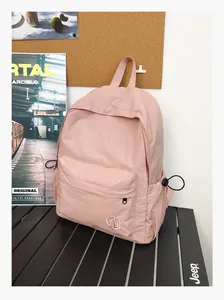 Vue détaillée d'un sac à dos rose minimaliste à texture quadrillée pour l'école