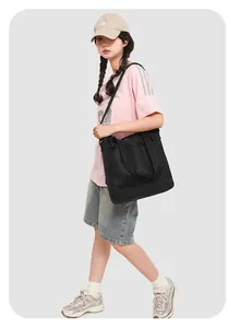 Vue latérale du cabas en maille noire avec bandoulière réglable porté par un mannequin