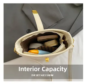 Capacité intérieure du sac seau beige avec doublure rayée et objets personnels