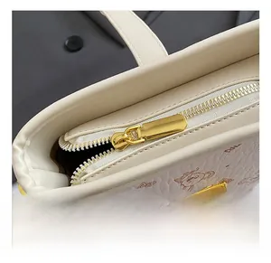 Détails de la fermeture dorée et texture grainée sur ce sac seau beige avec ourson