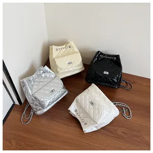 Detailed view of quilted chain backpacks in silver, beige, black, and pearl white colors