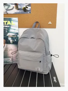 Détail du sac à dos à carreaux gris avec poches latérales à cordon et compartiment zippé