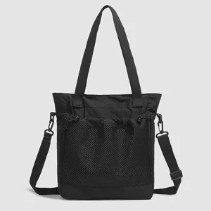 Vue détaillée du sac cabas en nylon noir avec poche filet et bandoulière amovible