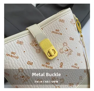 Détail du sac seau crème avec boucle dorée et imprimé de motif de souris de dessin