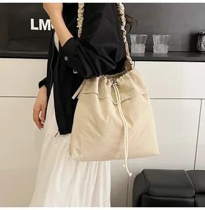 Dettaglio borsa a secchiello beige in nylon con coulisse e tracolla con volant eleganti