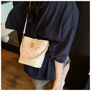 Vue détaillée du sac seau beige en cuir avec imprimé ours et fermoir en métal doré