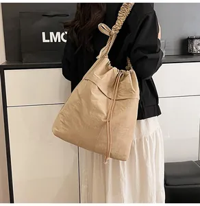 Dettaglio della borsa kaki con coulisse e tracolla con volant dal design esclusivo
