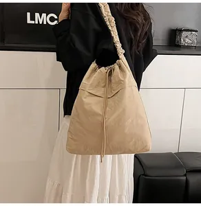 Dettaglio della borsa tote kaki con coulisse, tracolla plissettata e grande capienza