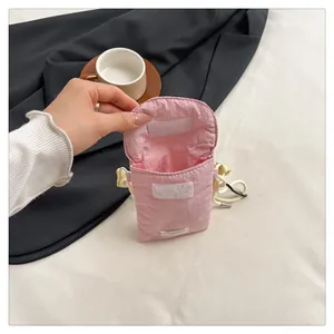 Pink fabric phone pouch featuring a flap velcro closure and slim white shoulder strap