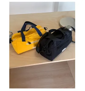 Dettaglio di borse a cilindro in nylon nero e giallo con tracolle regolabili