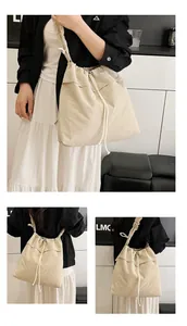 Dettaglio della borsa a secchiello beige con coulisse e tracolla con volant dal design unico