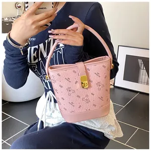 Vue détaillée du sac seau rose avec texture litchi et imprimé ours de dessin animé