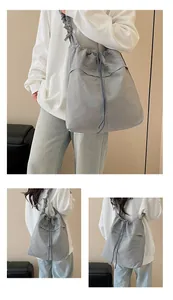 Dettaglio della grande borsa tote in nylon grigio con coulisse e tracolla a pieghe
