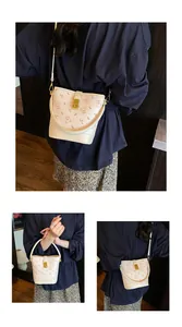 Détail du sac seau crème avec motifs d'ours, poignée en métal et fine bandoulière réglable