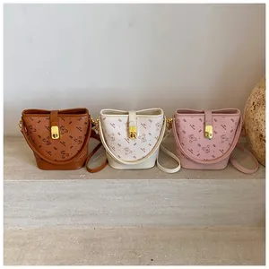 Vue détaillée de trois sacs seaux en marron, beige et rose avec imprimés d'ours
