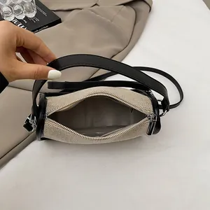 Classic small canvas bucket bag with black leather trim and top zipper from a top-down view