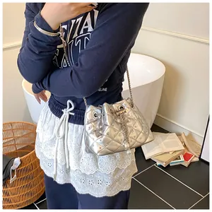 Close-up of silver quilted bucket bag with pearl drawstring and metal chain strap
