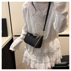 Détail du sac à bandoulière vintage noir à monogramme avec chaîne dorée et lanière en cuir