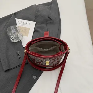 Fashionable red embroidered bucket bag with dragon patterns and organized inner pockets