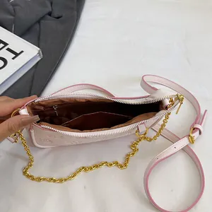 Sac sous le bras en cuir rose pâle avec motifs gaufrés et une chaîne dorée élégante