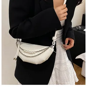 Dettaglio borsa a tracolla bianca a mezzaluna con trama intrecciata, perle e catena d'argento